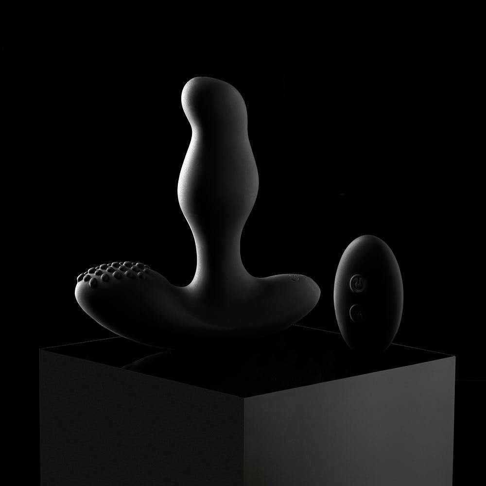 male prostate vibrator photographed in dim light with shadows 