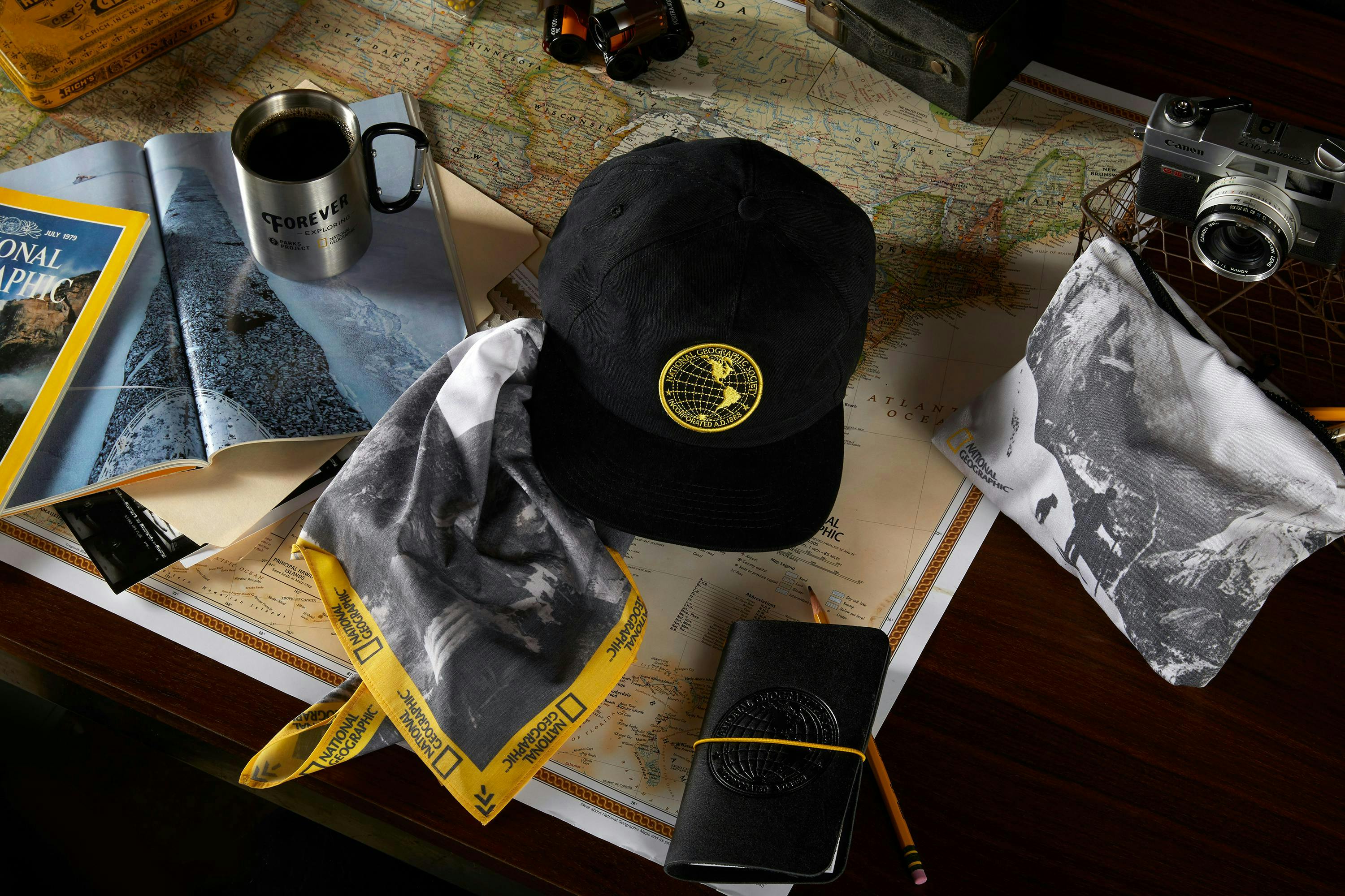 National Geographic apparel photoshoot with hat, magazine, passport and various adventure gear 