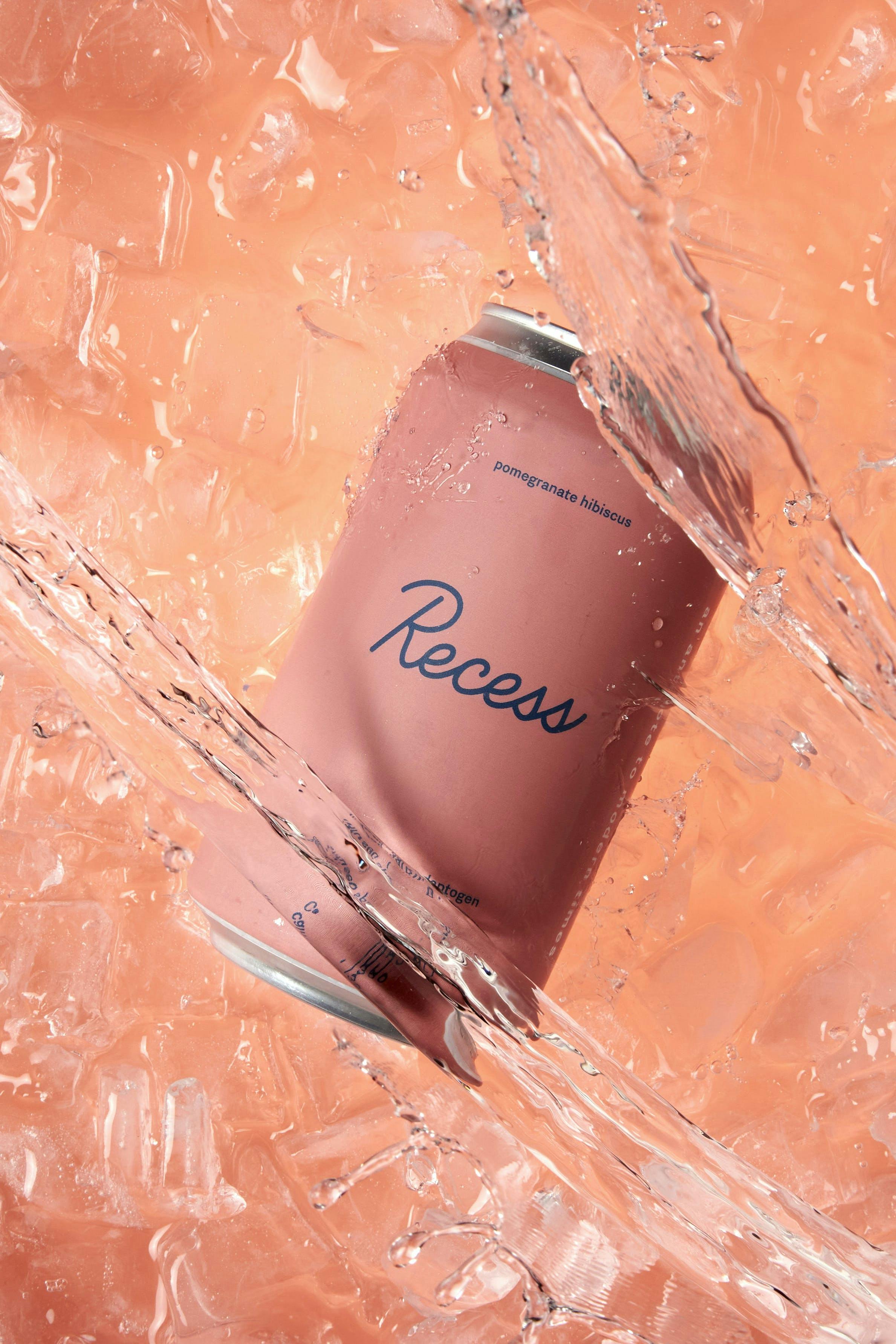 Recess beverage can with lively splashes in crystal-clear water, capturing the essence of energy and refreshment