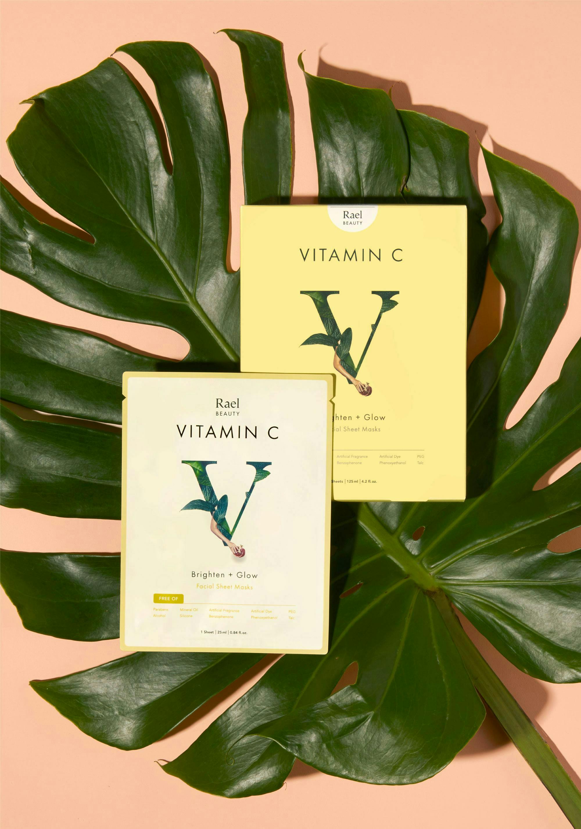 flat lay photography arial shot of vitamin c supplements in packaging place on a monstera leaf against a peach background 
