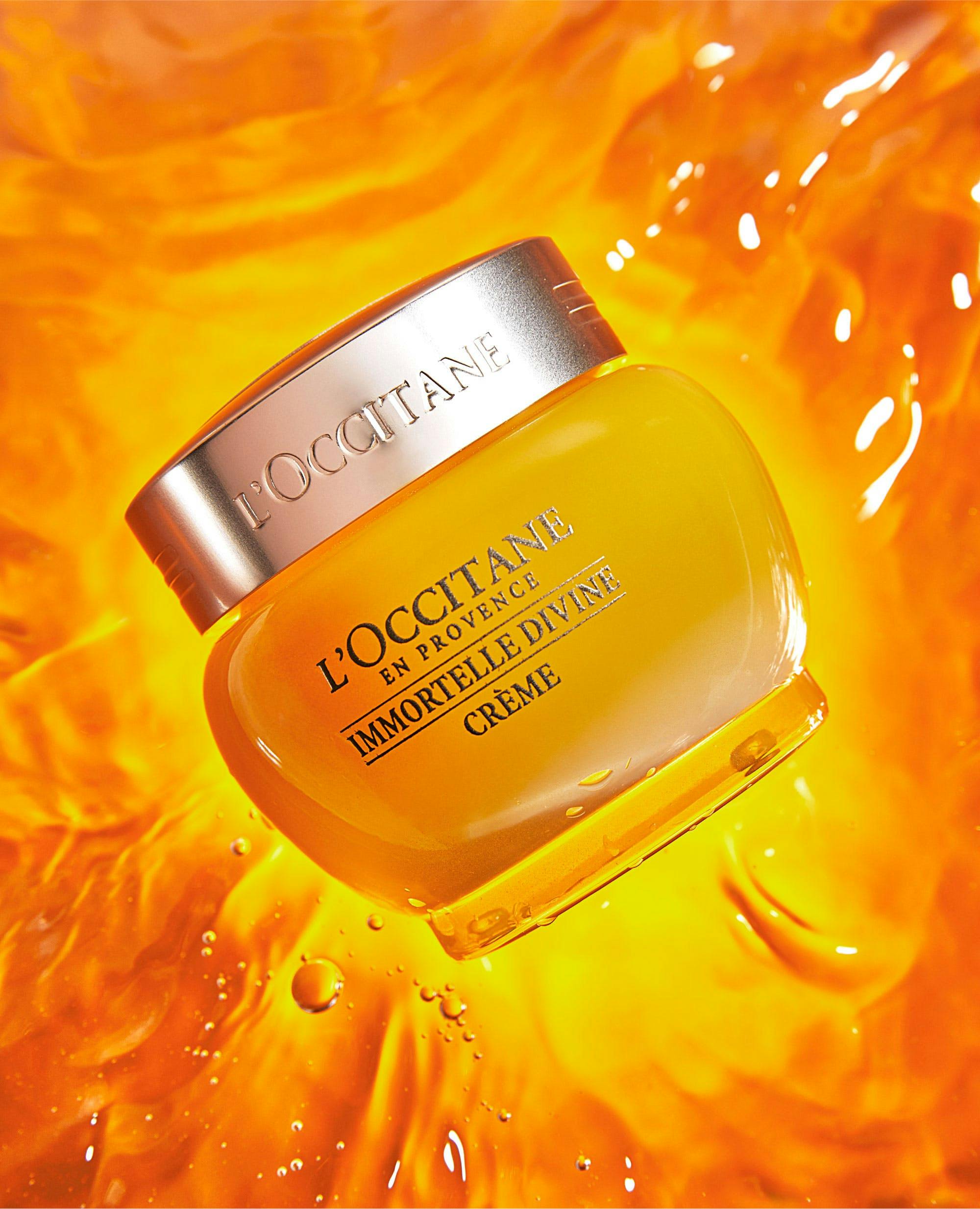 bright orange back splash with L'Occitane creme bottle centered in the image 