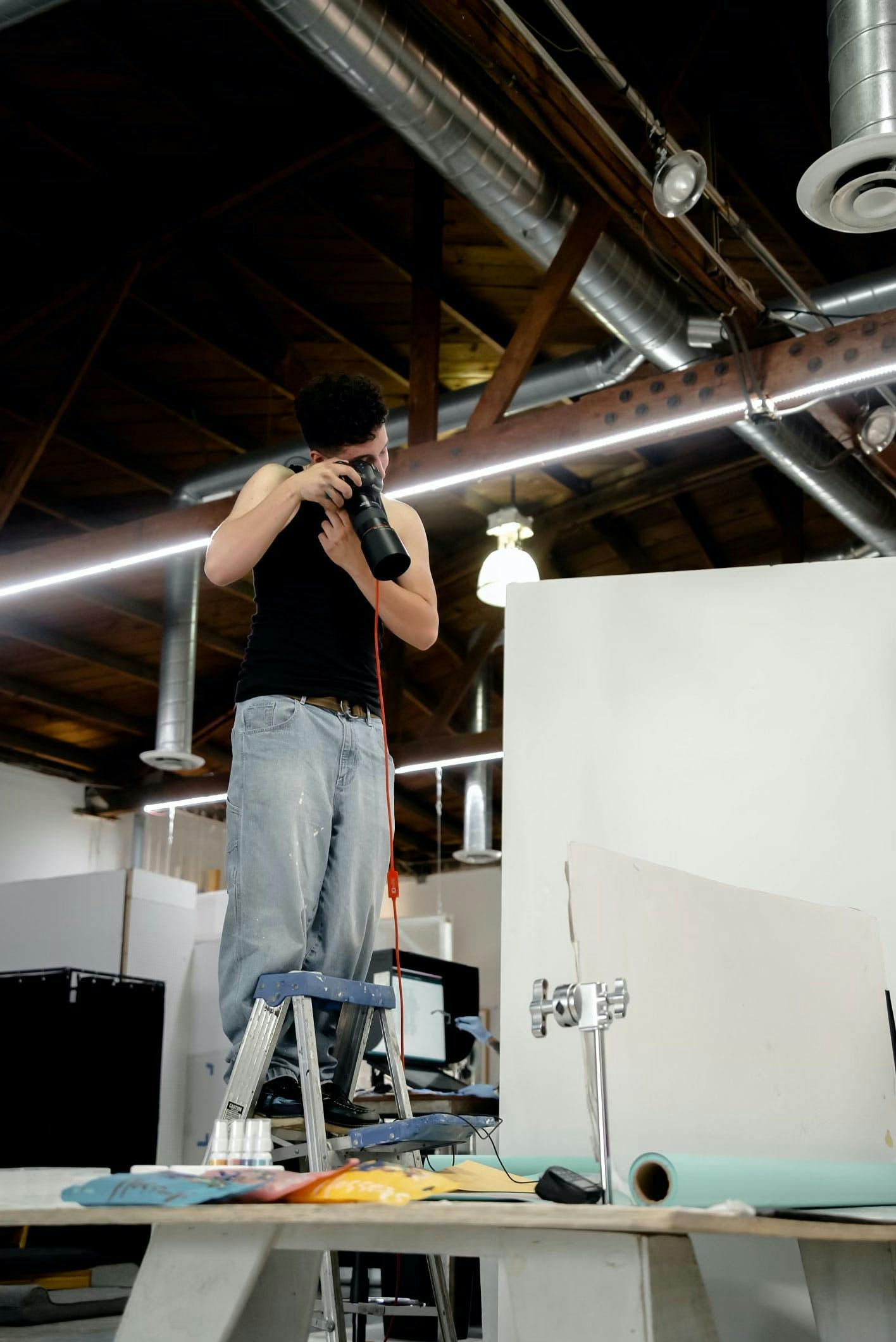 A photographer standing on a ladder, shooting from above to capture detail shots