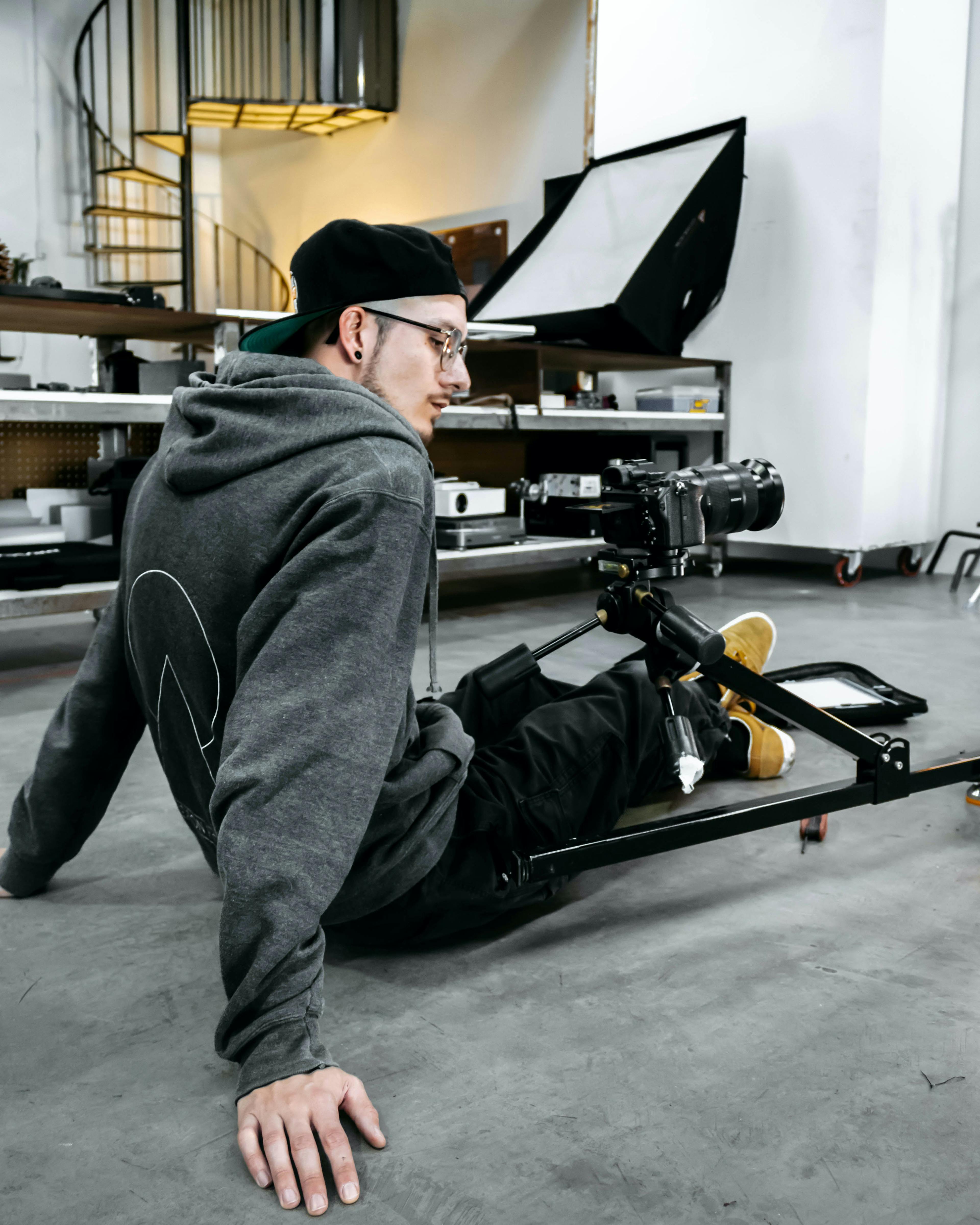 Photographer carefully adjusting the camera on a 360 rig, a tripod-like device that enables capturing images from all angles, in a photography studio.