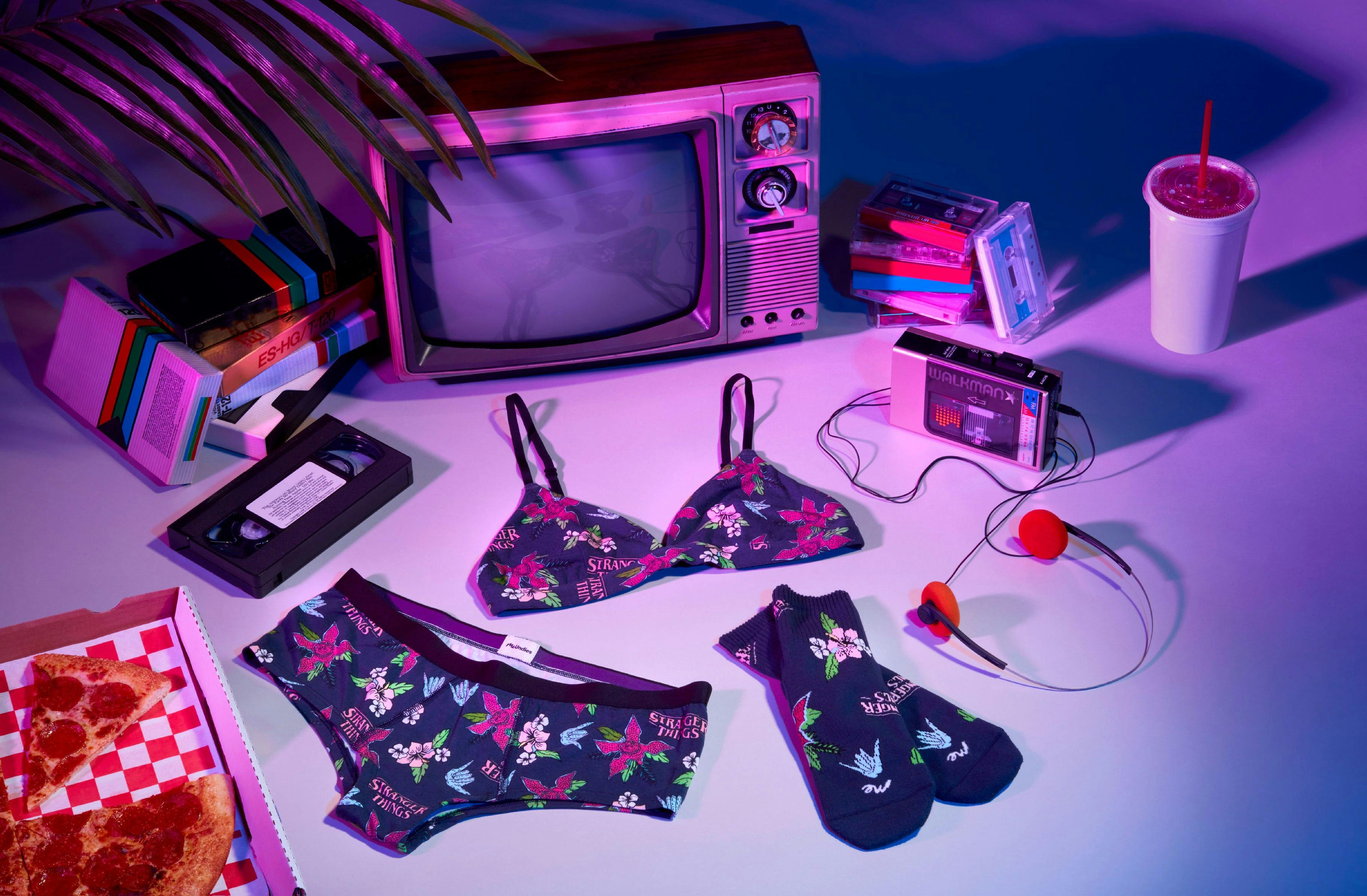 flay-lay photography with a tv, pizza, undergarments and socks, cool tones 